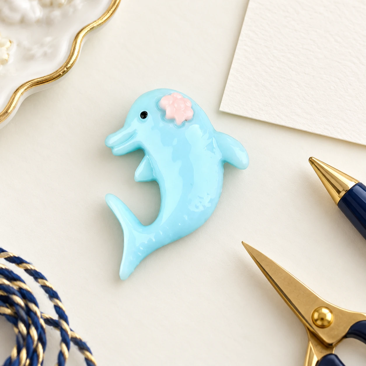 Blue Dolphin Resin Charm RW001078 in an illustrative craft workspace
