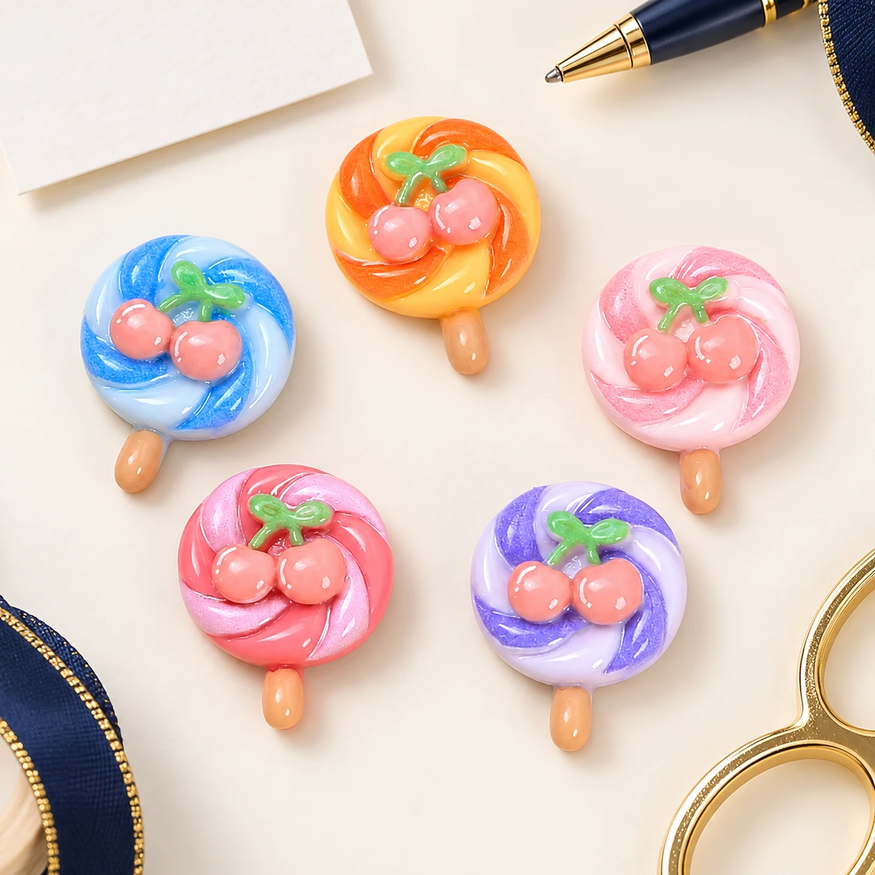 Cherry Swirl Lollipop Resin Charms RW003313 in an illustrative craft workspace
