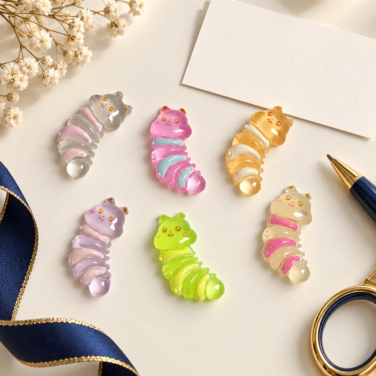 Colorful Caterpillar Resin Charms RW001391 in an illustrative craft workspace