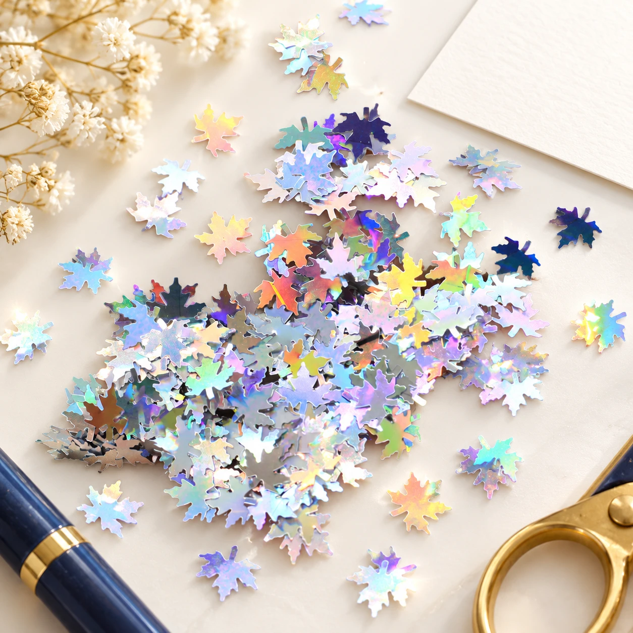 Holographic Maple Leaf Sequins MA129 in an illustrative craft workspace