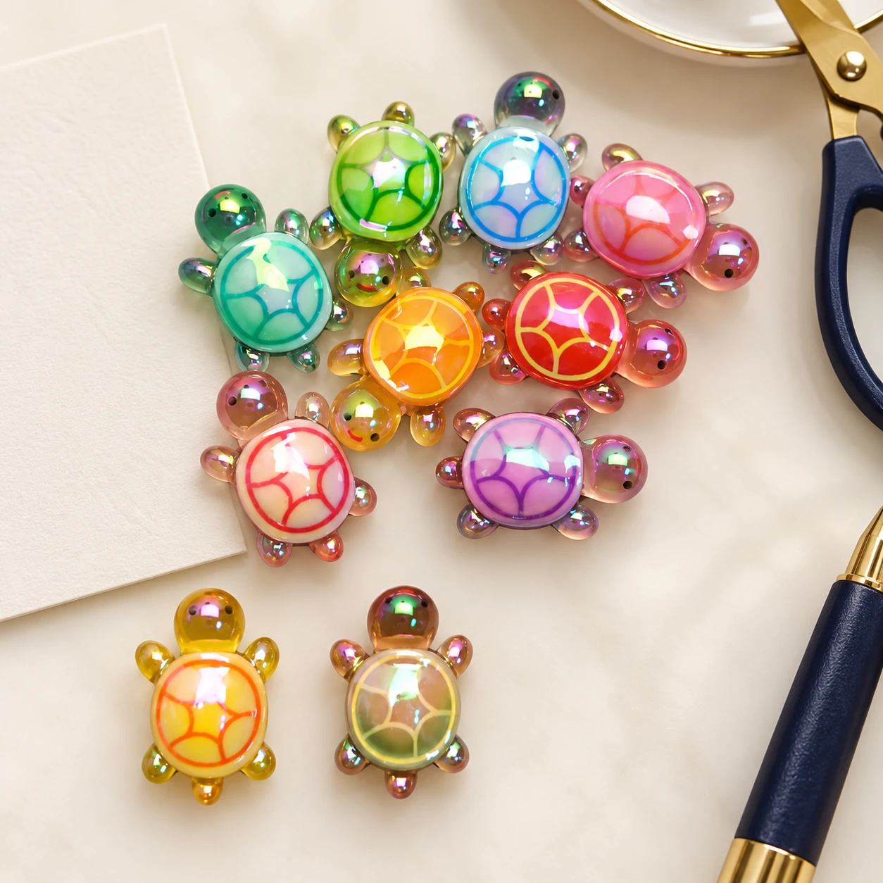 Iridescent Mini Turtle Resin Charms RW0026057 in an illustrative craft workspace