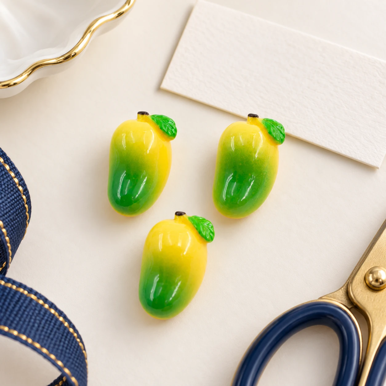Mini Mango Resin Charms RW0023325 in an illustrative craft workspace