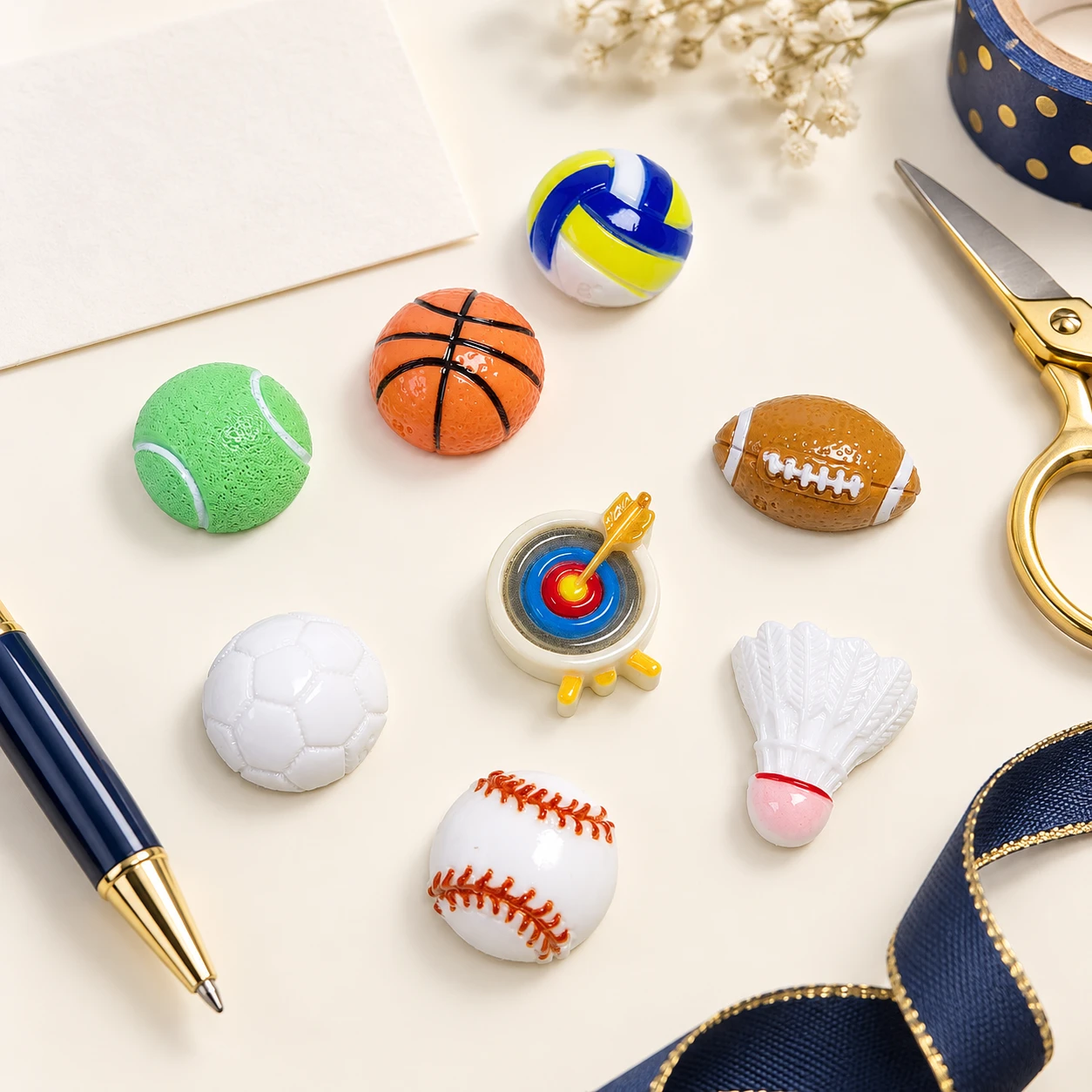 Sports Ball and Equipment Resin Charms RW002640 in an illustrative craft workspace