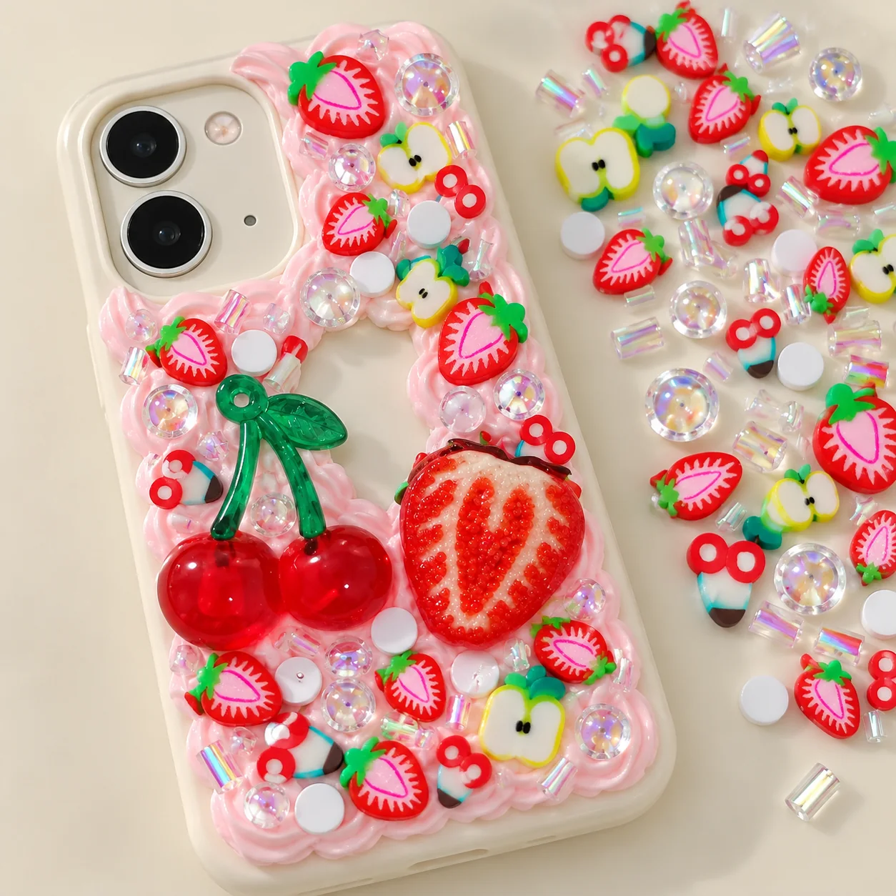 Illustrative cream-glue phone case decorated with cherry and strawberry filler charms