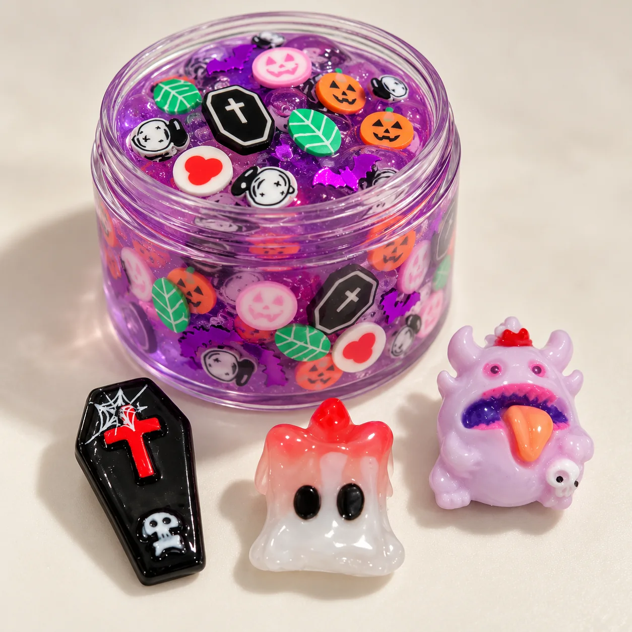 Illustrative purple slime jar with Halloween slices and large resin focal charms beside it