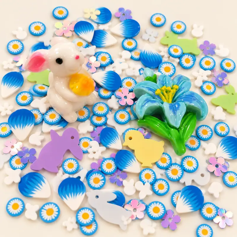 Studio overview of a white rabbit and blue flower focal charms among blue-white daisy fillers
