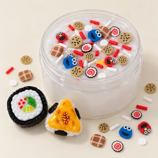 Illustrative clear slime jar with small cookie and face motifs; large focal charms placed beside it