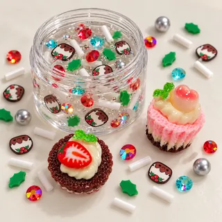 Illustrative clear slime jar with small holiday pudding pieces while tart and cupcake charms rest outside