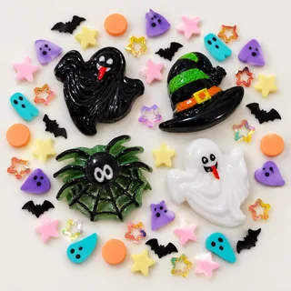 Close view of black and white ghost charms, green-banded witch hat and spider-web charm with pastel pieces