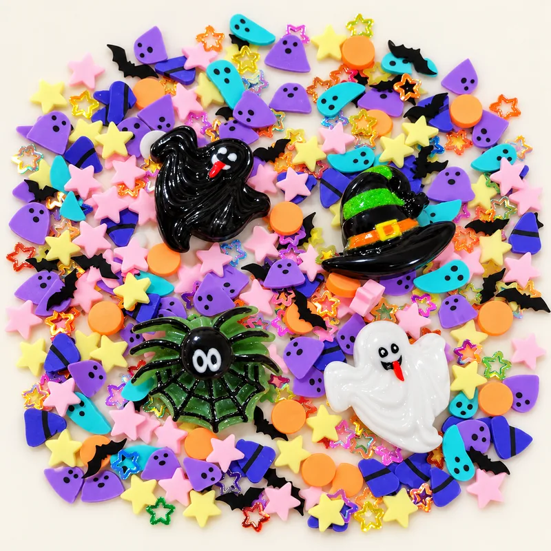 Studio overview of black and white ghosts, witch hat and spider web charms among pastel Halloween filler pieces