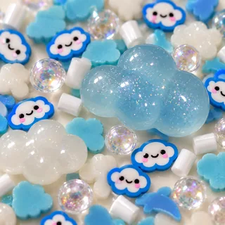 Close detail of a pale-blue dimensional cloud charm beside smiling cloud slices and clear beads