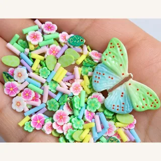 Studio overview of one pastel green-blue butterfly with pink-white flower slices, green accents and pastel rods