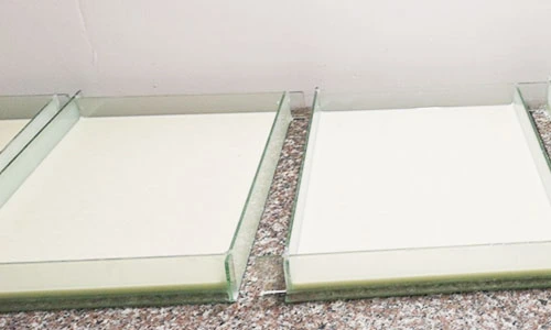 Two shallow rectangular frames filled with light-coloured mould material
