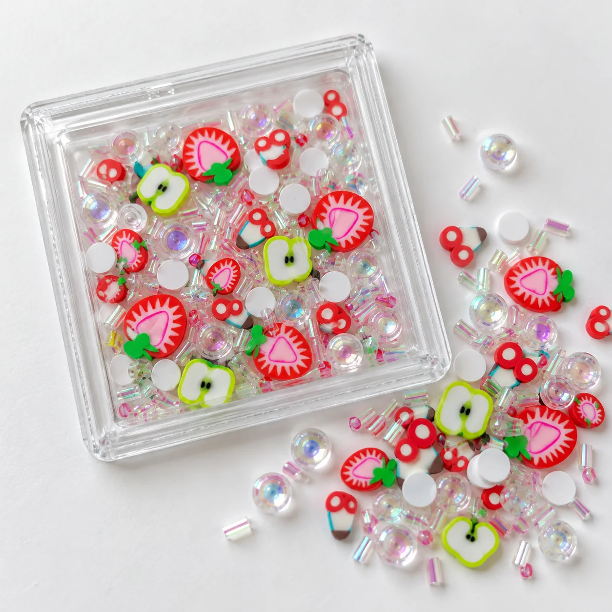 Illustrative dry shaker card filled with strawberry and apple clay slices and iridescent accents