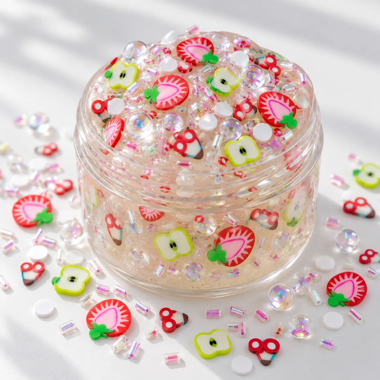 Illustrative clear slime jar decorated with strawberry and apple clay slices